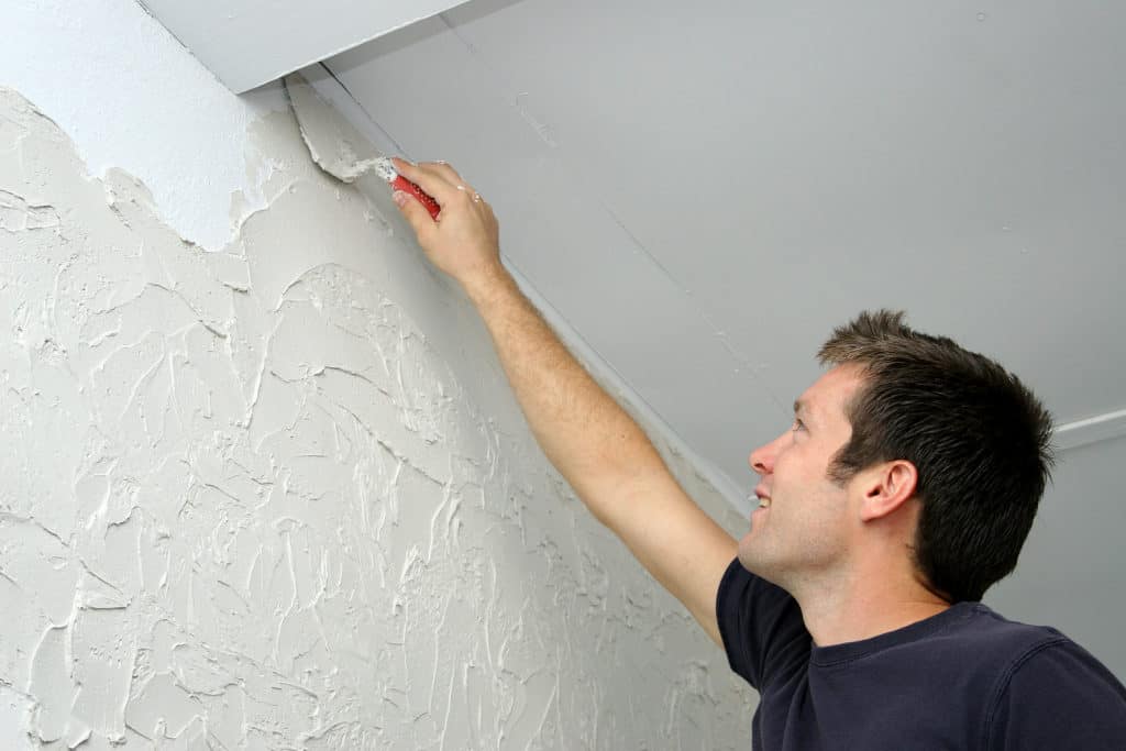 man texturizing a wall