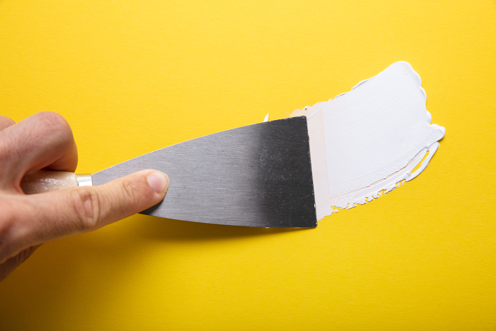putty knife on yellow wall